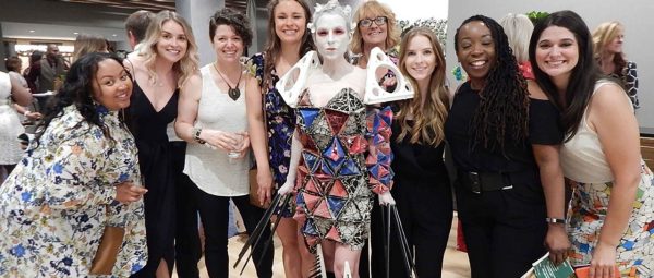 Stantec interior designer and MERGE Fashion Show model Rebecca Keehner is surrounded by other team members on the night of a runway show.