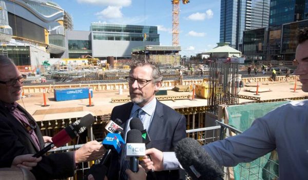 Keith Shillington, senior vice president, talking with reporters in front of Stantec Tower construction site.