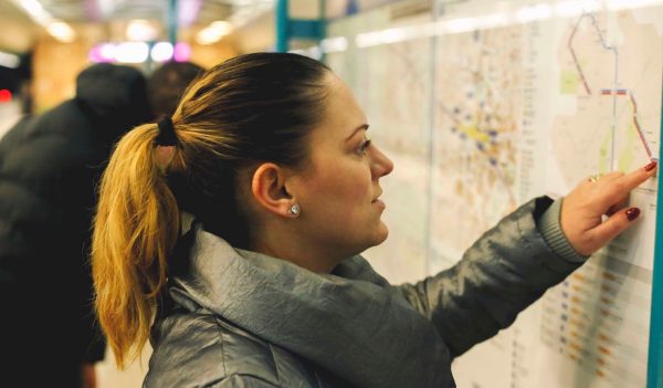 Tourist girl in metro, looking at the map