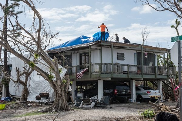 Big Pine Key, FL - Workers begin repairs on the roof of this house which was damaged during Hurricane Irma