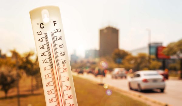 Thermometer in front of an urban scene during heatwave in Montreal