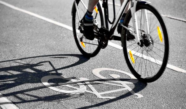Cyclist casting a shadow on bicycle symbol on cycling lane